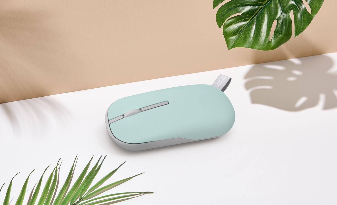 Brave Green renkli bir ASUS Marshmallow Fare MD100, köşede yaprak olacak şekilde masanın üzerine yerleştirilmiştir.