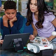 Bir tablet ile bir robot programlayan erkek ve kız öğrenci