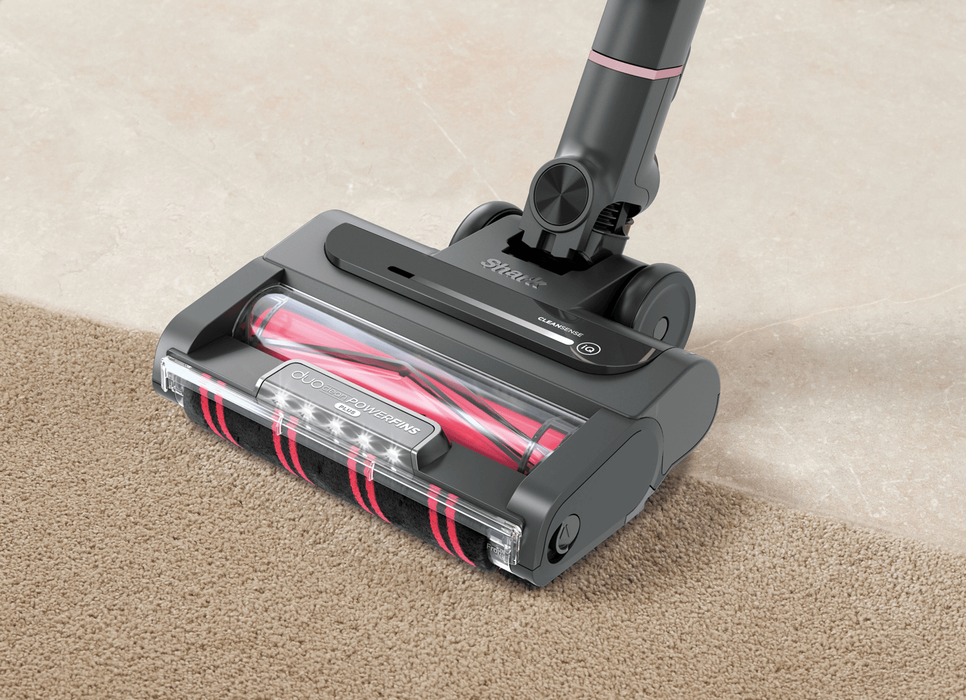 Vacuum cleaner being used in a modern living room, with a dog sitting on the carpet