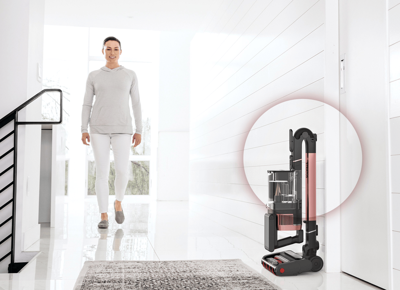 Vacuum cleaner being used in a modern living room, with a dog sitting on the carpet