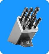 Mavi arka plana karşı çapraz blok tutucudan çıkıntı yapan çok sayıda bıçak saplı gri bıçak bloğu seti.