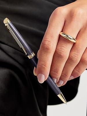 Siyah kumaş arka plan üzerinde parmaklarda altın yüzükler giyen ve ayarlayan ellerin yakın çekim sırası. Yüzüklerin farklı yerleştirme açılarını gösterir.