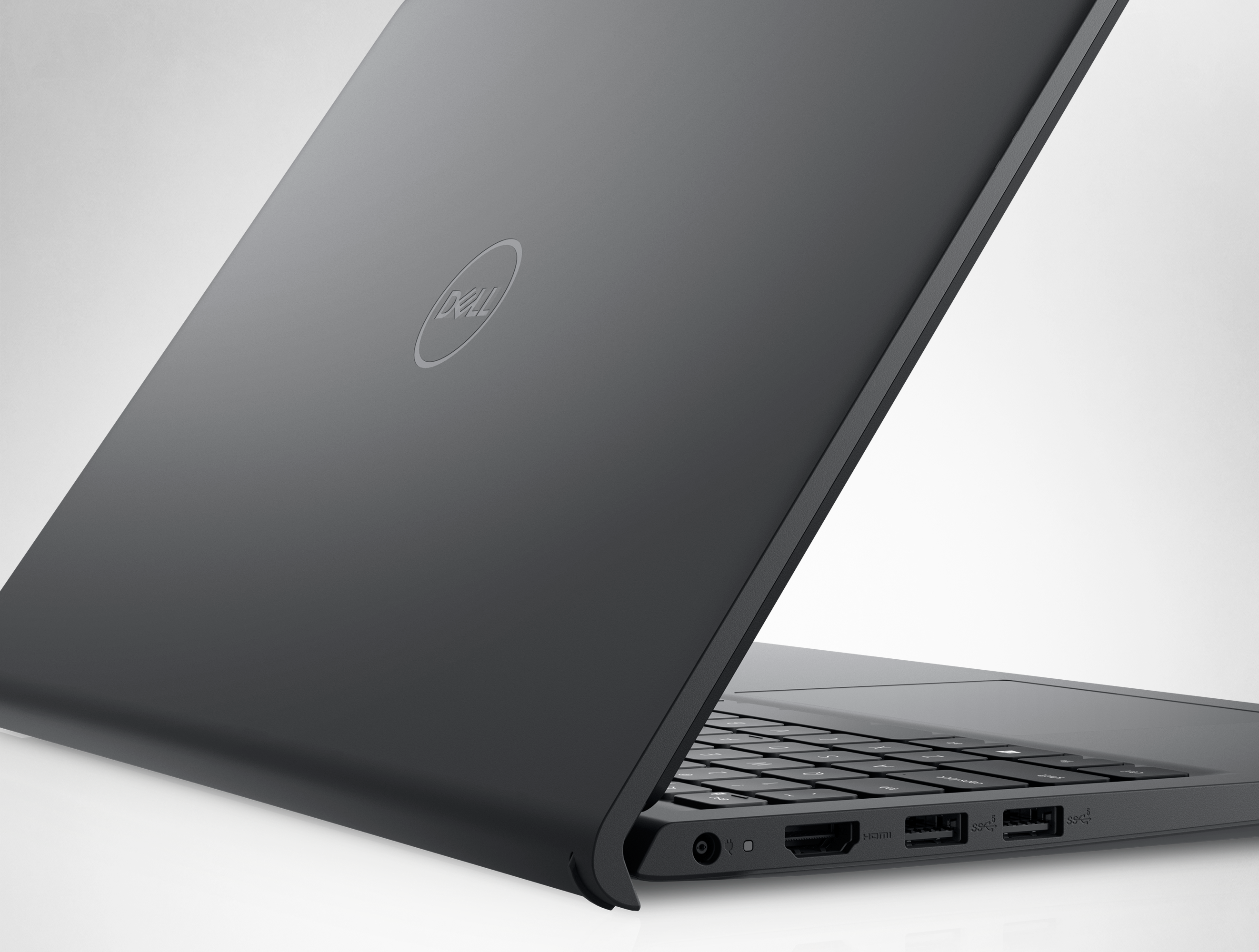 Arkasına yaslandırılmış ve Dell logosu görünen açık Dell Inspiron 15 3520 Dizüstü Bilgisayarın resmi.
