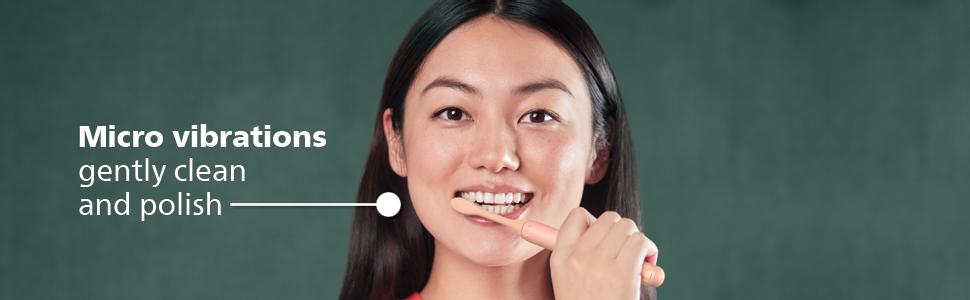 woman with dark hair brush teeth with pink toothbrush