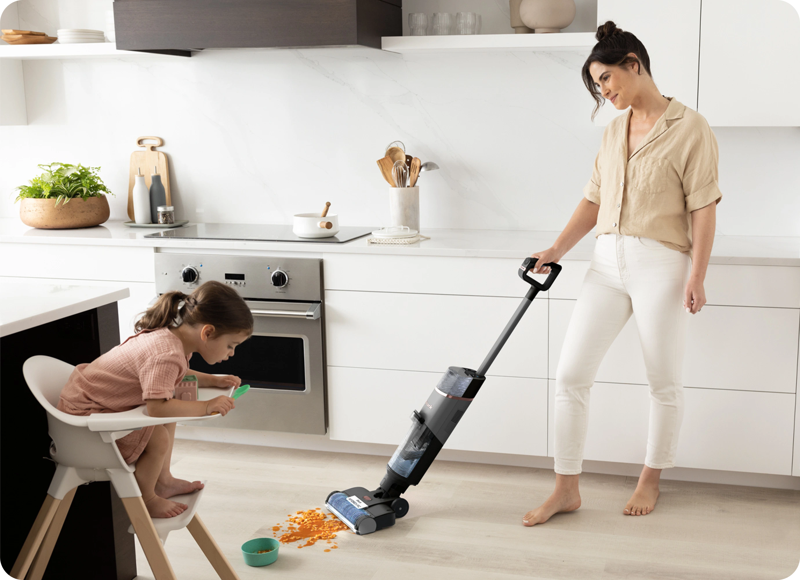 Woman using vacuum in kitchen